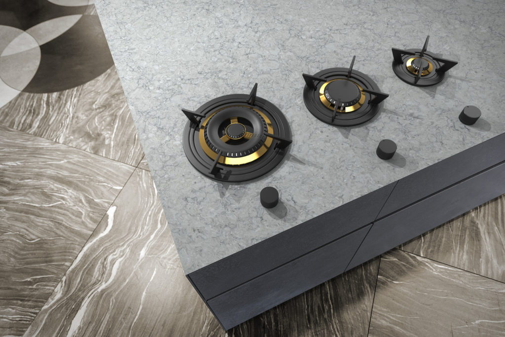 Three black burners on a gray marble countertop